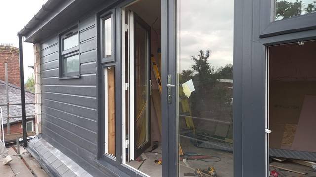 Grey cladding and aluminium door frame on a new extension