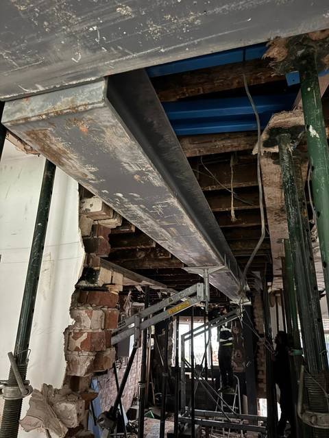 Steel beam supported on props above the ceiling joists during a wall removal